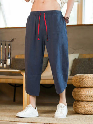 Navy blue cropped sweatpants for men with red drawstring and cuffed hems.