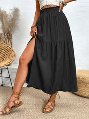 Black textured tiered maxi skirt with a high slit and smocked waist.