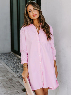 Oversized pink cotton shirt dress with button front and curved hem.