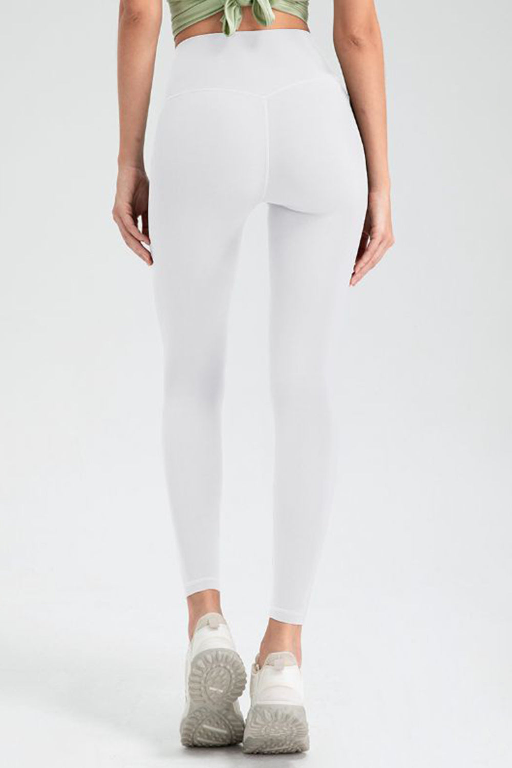 White high rise leggings with a seamless back detail and athletic shoes.