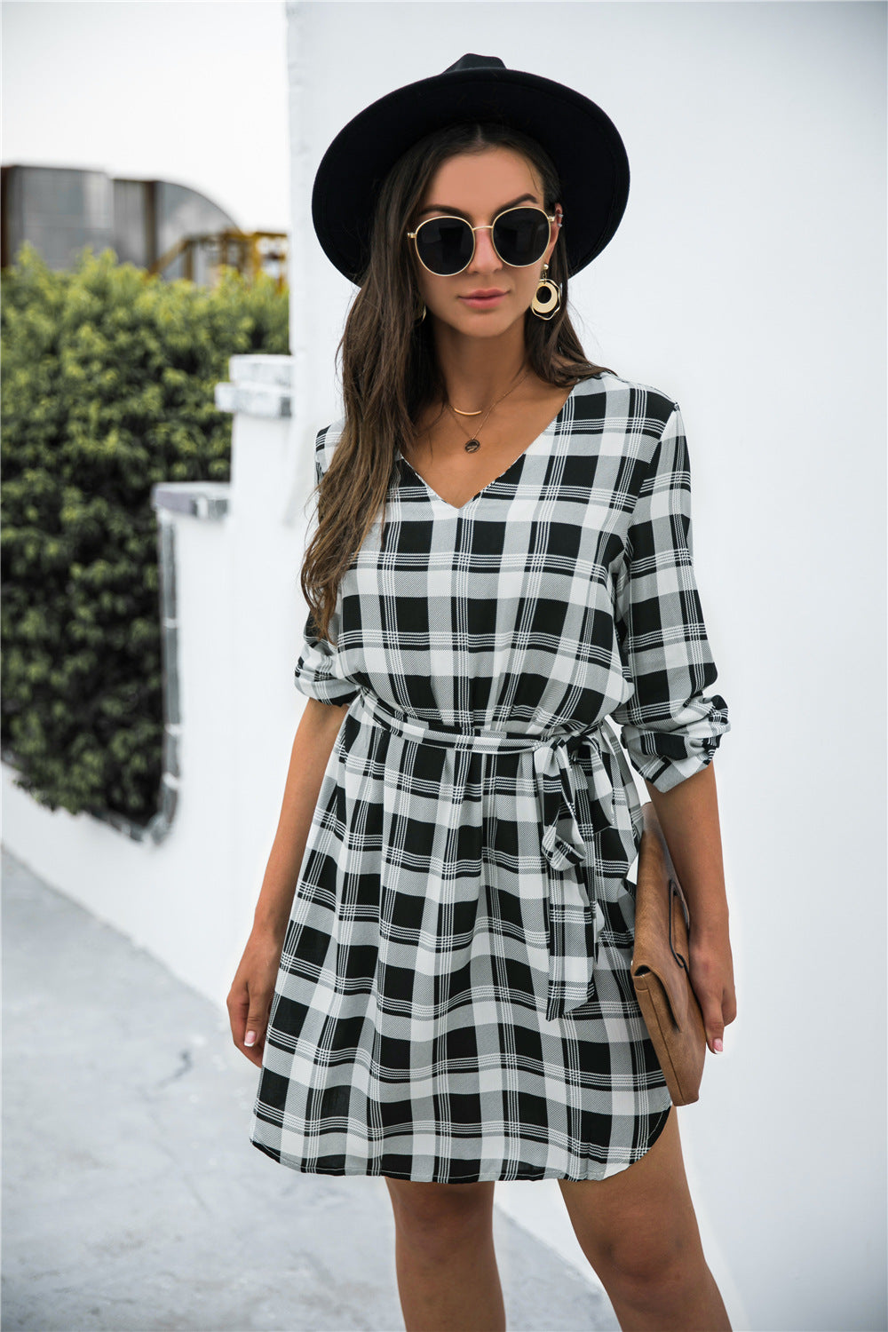 Black plaid shirtdress with V-neck, 3/4 sleeves, and belted waist.