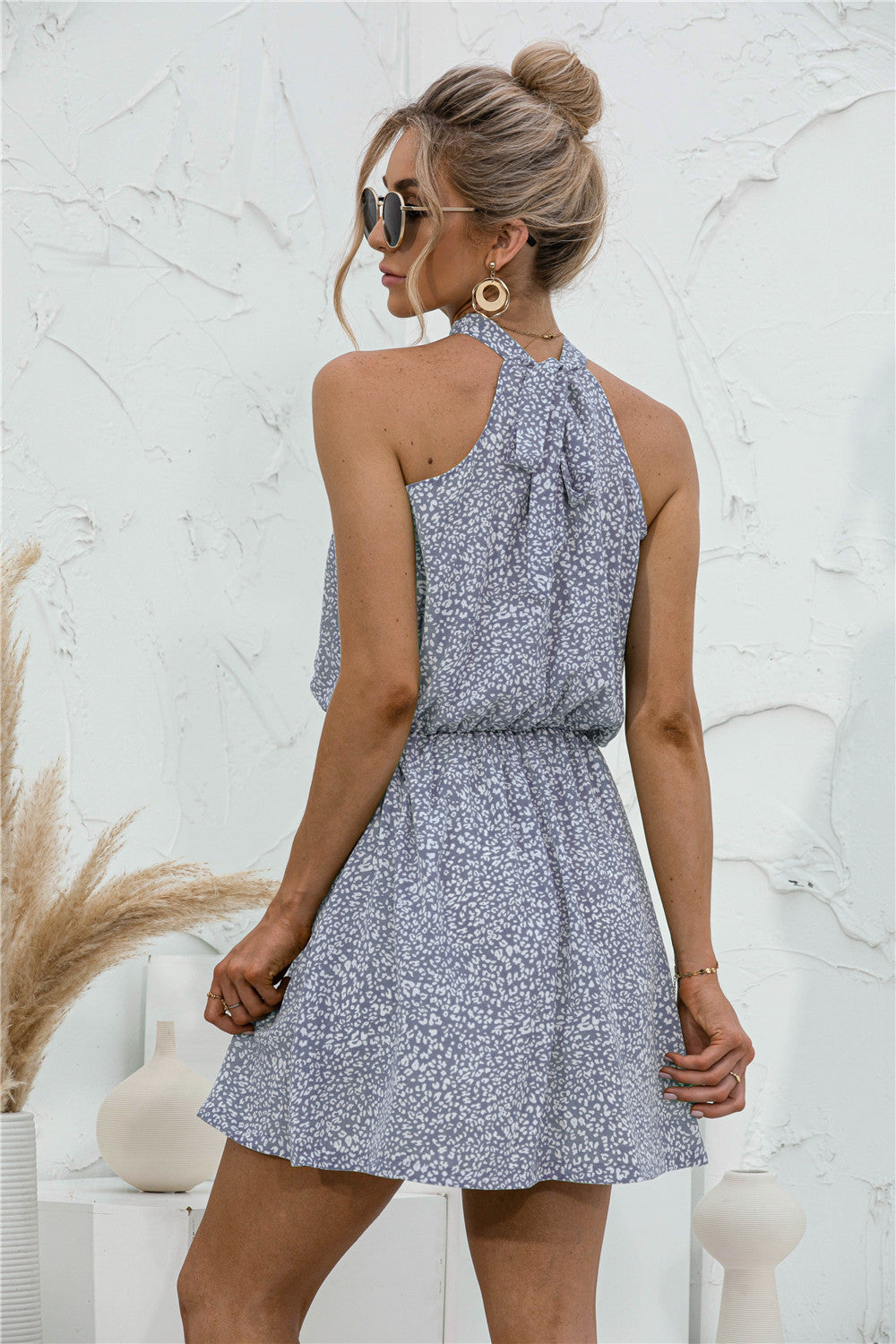 Misty blue floral halter neck mini dress with elastic waist and tie back detail.