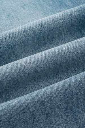 Button-fly wide-leg denim trousers in medium wash, showing fabric texture.
