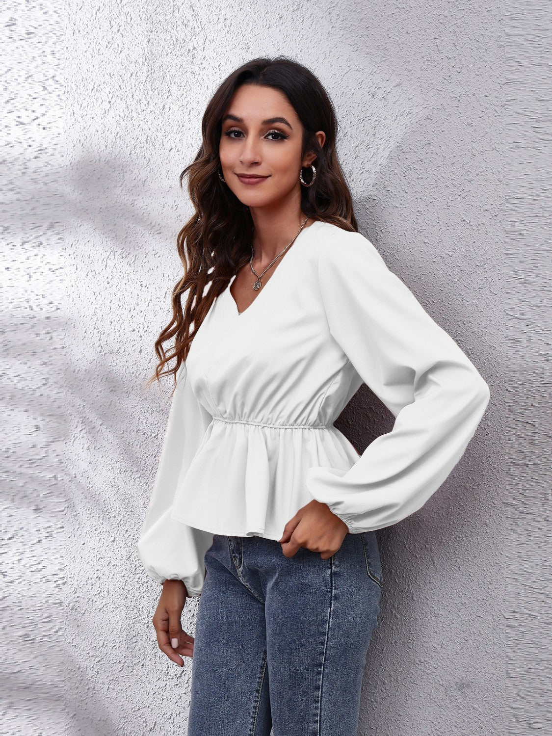 White peplum blouse with V-neck, gathered waist and balloon sleeves.