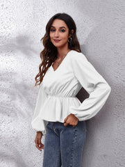 White peplum blouse with V-neck, gathered waist and balloon sleeves.