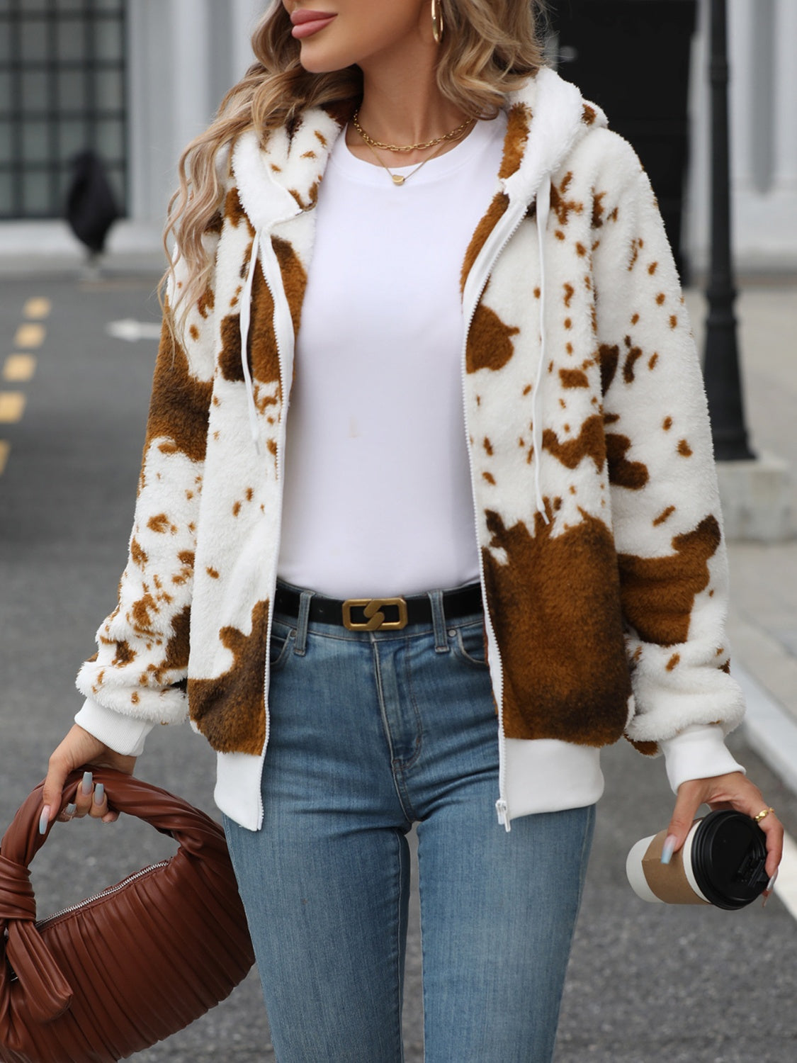 Brown cowhide print sherpa zip-up hoodie with white trim and hood.