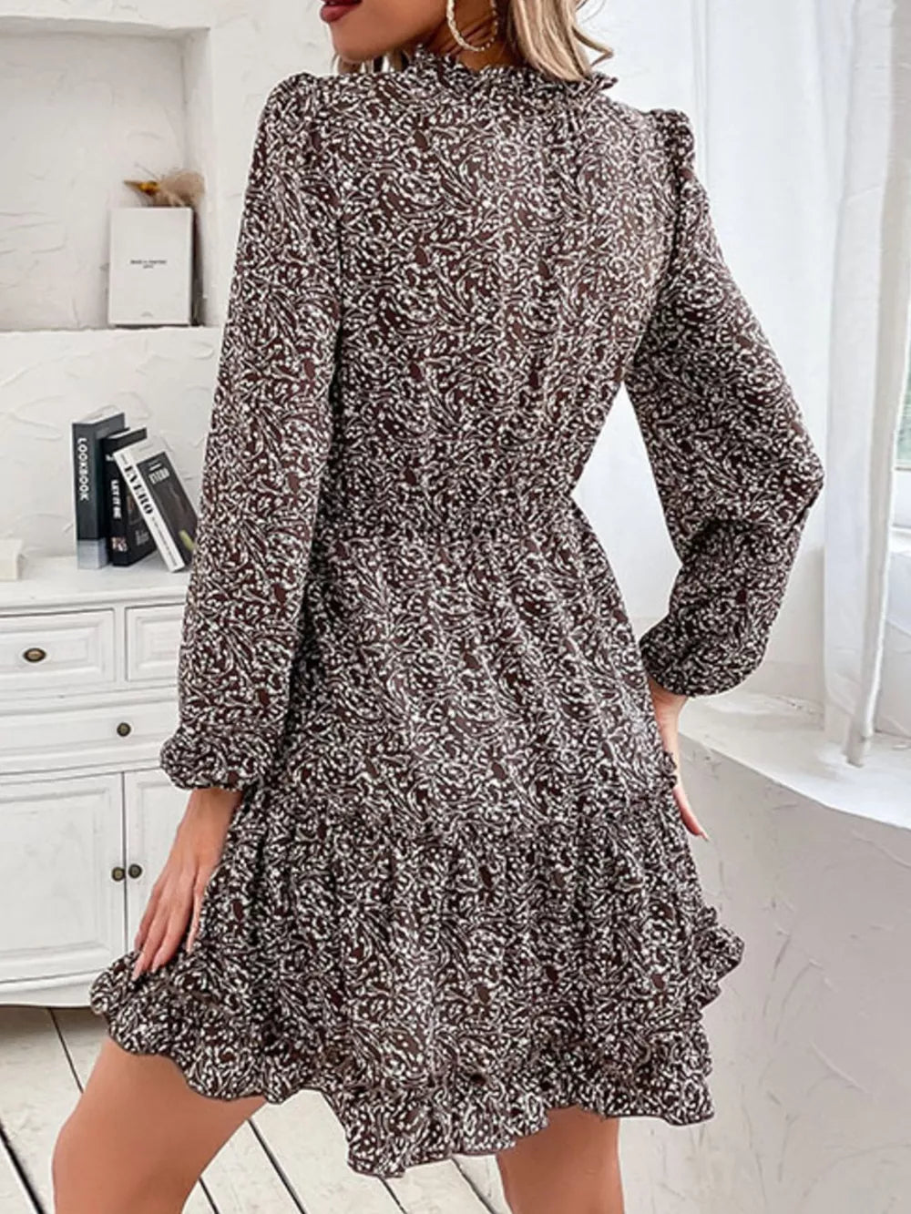 Ruffled tie neck floral mini dress in dark brown with long sleeves and tiered hem.