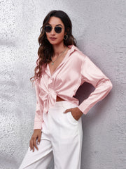 Blush pink silken button-down shirt with a tie front and long sleeves.