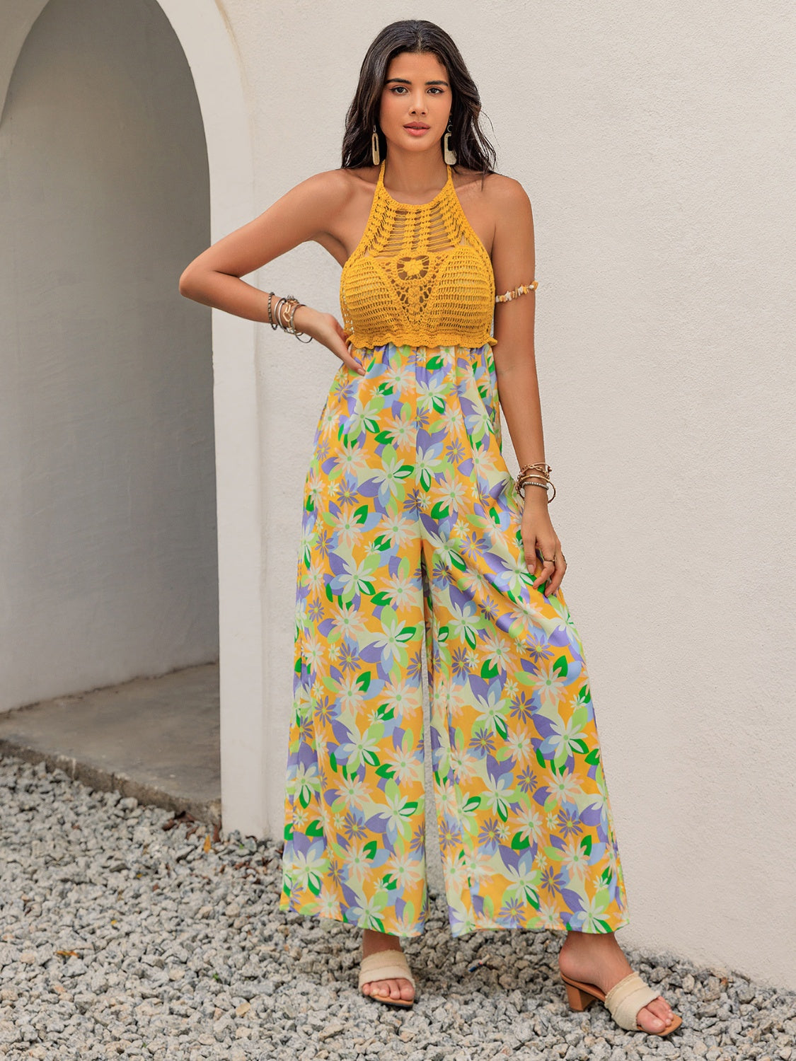 Gold crochet halter jumpsuit with a vibrant floral print and wide palazzo legs.