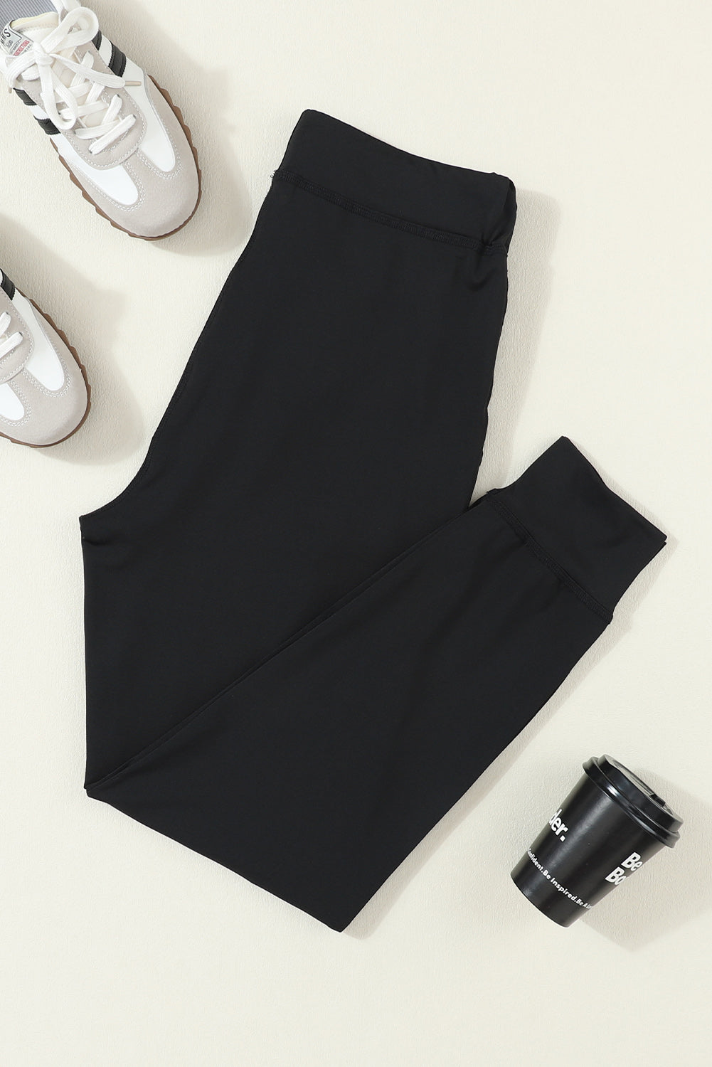 Black slim-fit joggers with drawstring waist and cuffed ankles.