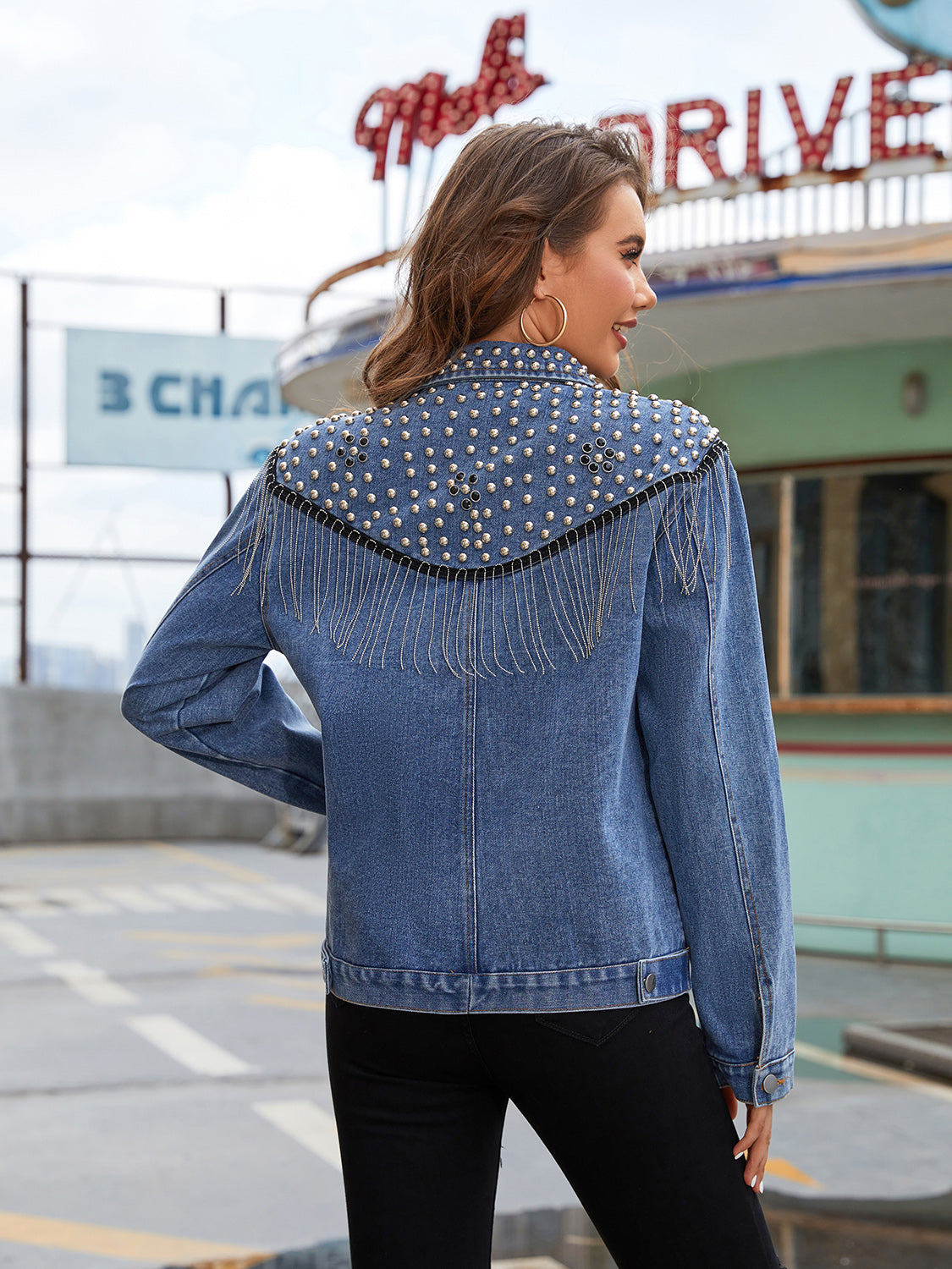 Denim trucker jacket in deep teal with studded fringe shoulder detail.