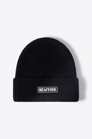 Black ribbed acrylic beanie with a New York patch detail.
