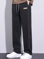 Black relaxed fit men's sweatpants with drawstring and logo patch
