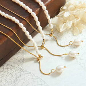 Gold asymmetrical lariat necklace with pearls and adjustable chain detail