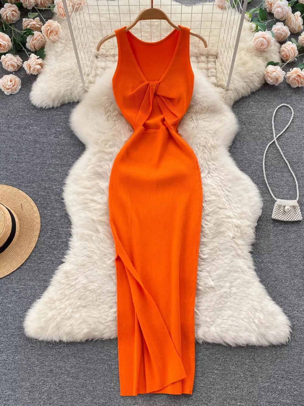 Orange ribbed knit midi dress with knot-back cutout detail and V-neck.