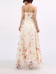 Strapless ivory tulle maxi dress with floral appliques, sweetheart neckline, A-line skirt.
