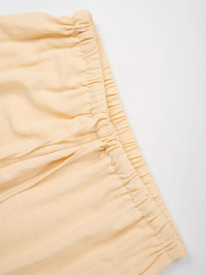 Pastel yellow maternity pants with drawstring waist and wide legs.