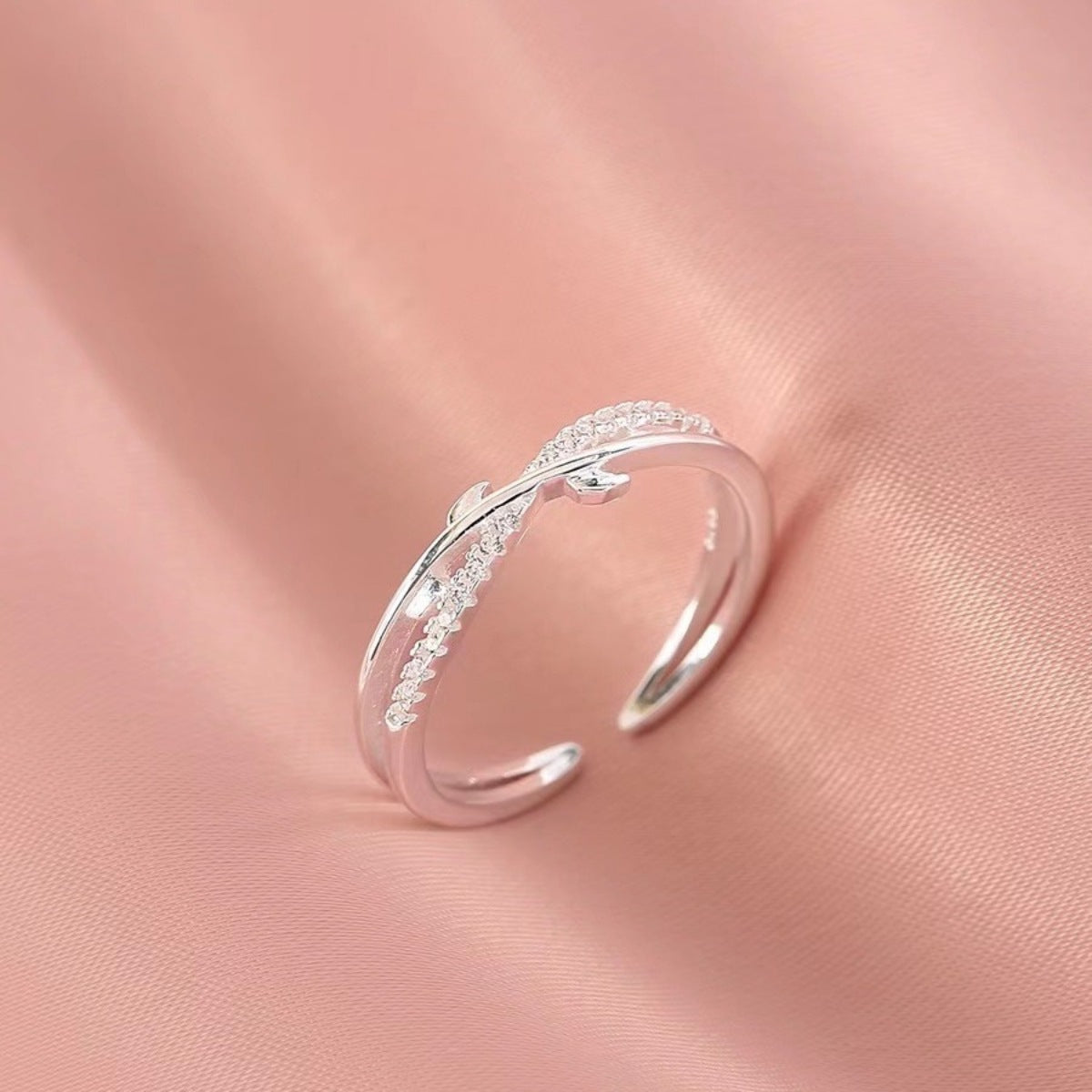 Sterling silver crossover ring with delicate pave crystal detail.