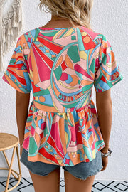 Multicolor geometric print peplum blouse with short sleeves and tassels.