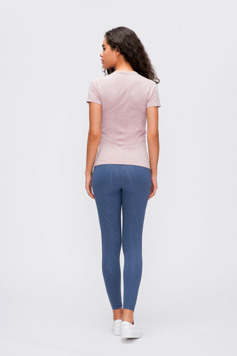 Sculpted Active Seamless Tee in blush pink with short sleeves, paired with blue patterned leggings.