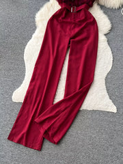 Wine red belted strapless wide-leg jumpsuit with feather trim detail.