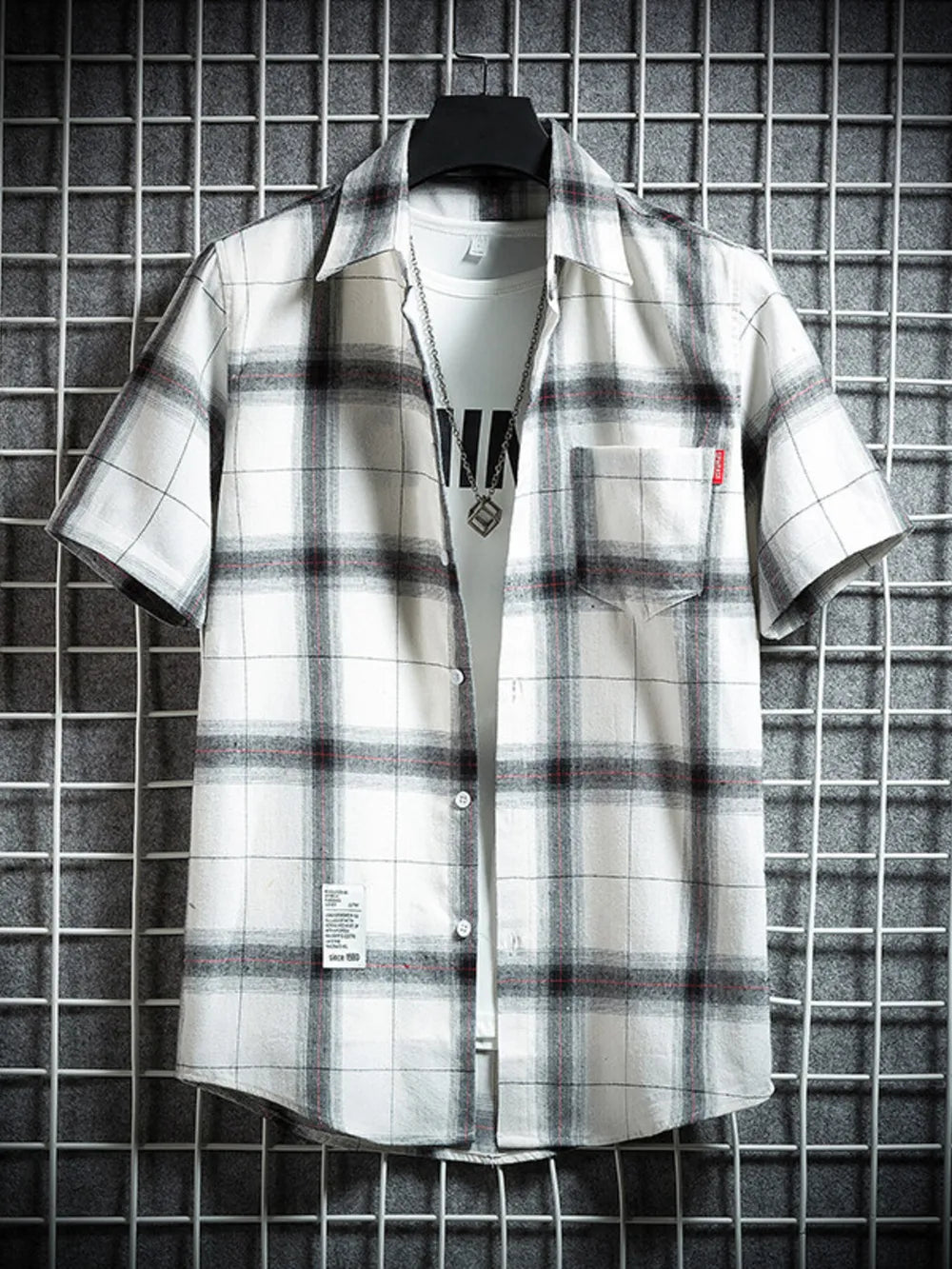 Classic plaid short-sleeve men's cotton shirt in white with black and red checks, featuring a chest pocket.