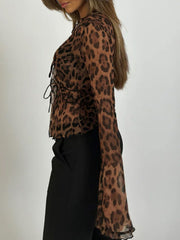 Chic animal print mesh blouse with tie detail and bell sleeves.
