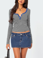 Striped henley shirt with blue contrast collar and button detail.