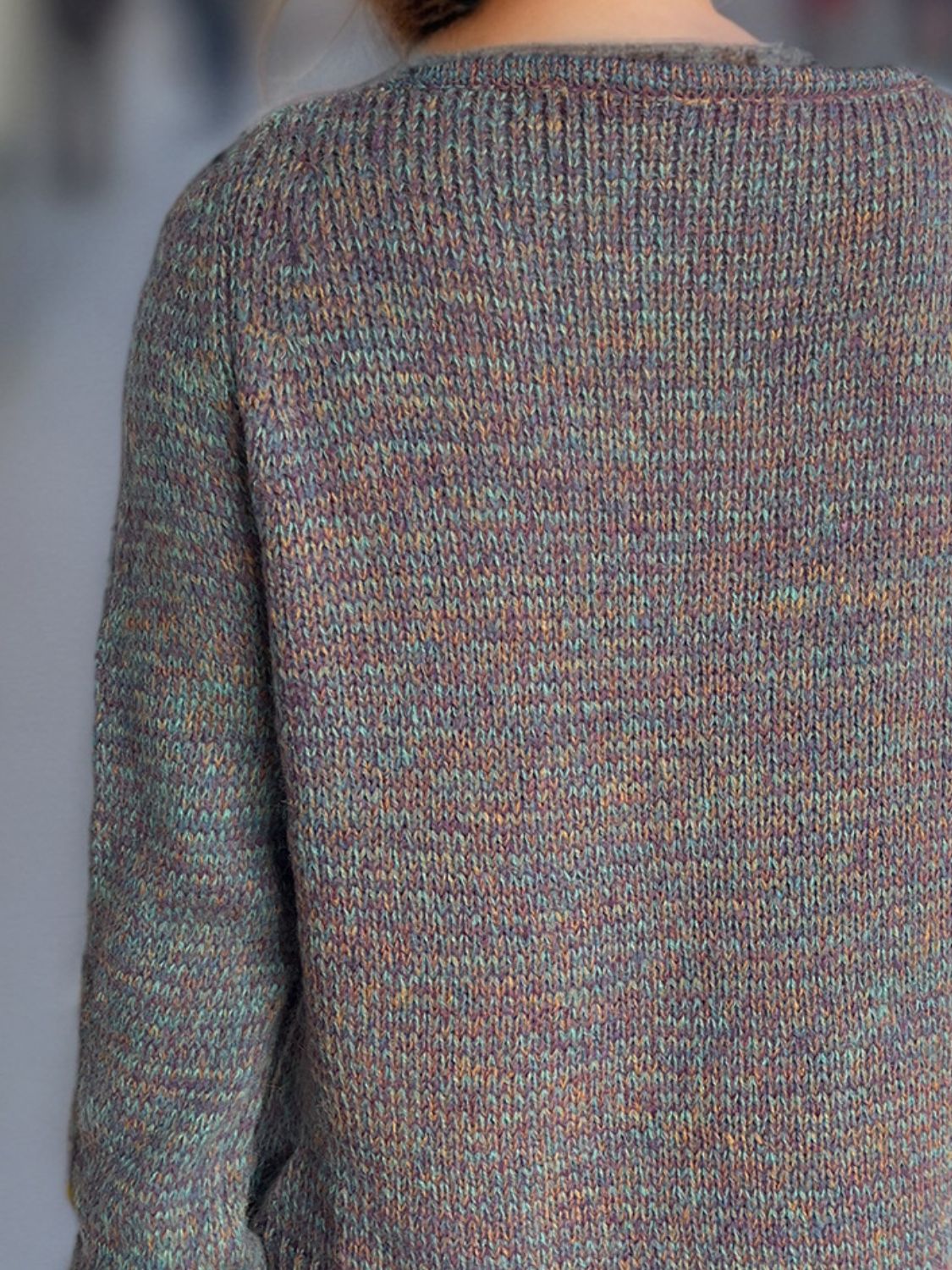 Textured knit sweater with a V-neck and long sleeves in a marled dusty pink and mauve acrylic blend.