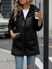 Black teddy hoodie with quilted panel detail and zip front, styled casually.