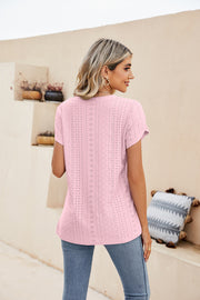 Blush pink knit top with eyelet details and short sleeves.