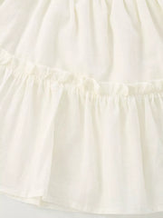 Cream tiered toddler dress with ruffled details and a cotton blend fabric.
