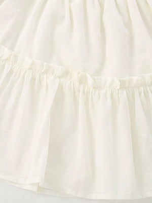 Cream tiered toddler dress with ruffled details and a cotton blend fabric.