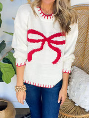 Ivory knit sweater with red bow detail and contrast stitching.