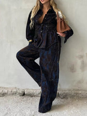 Denim jacket and pants set in dark blue with lace-up detail and abstract pattern.