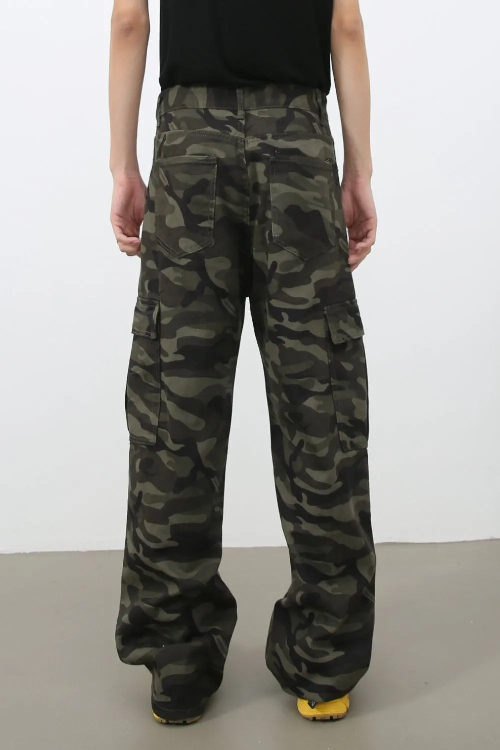 Wide-leg camo cargo pants in green camouflage, 100% cotton, with multiple pockets.