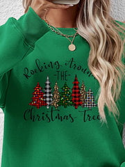 Green crewneck sweatshirt with graphic Christmas trees and "Rocking Around The Christmas Tree" text.