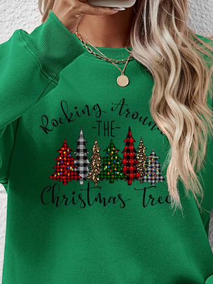 Green crewneck sweatshirt with graphic Christmas trees and "Rocking Around The Christmas Tree" text.