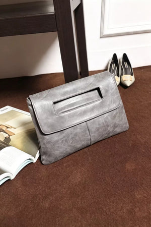Timeless Envelope Clutch in distressed light gray leather with cut-out handle detail.