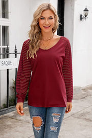 Wine raglan v-neck top with striped sheer sleeves.
