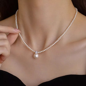 Luminous pearl pendant choker necklace with a single pearl drop and crystal accent.