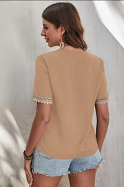 Brown V-neck blouse with lace trim on short sleeves.