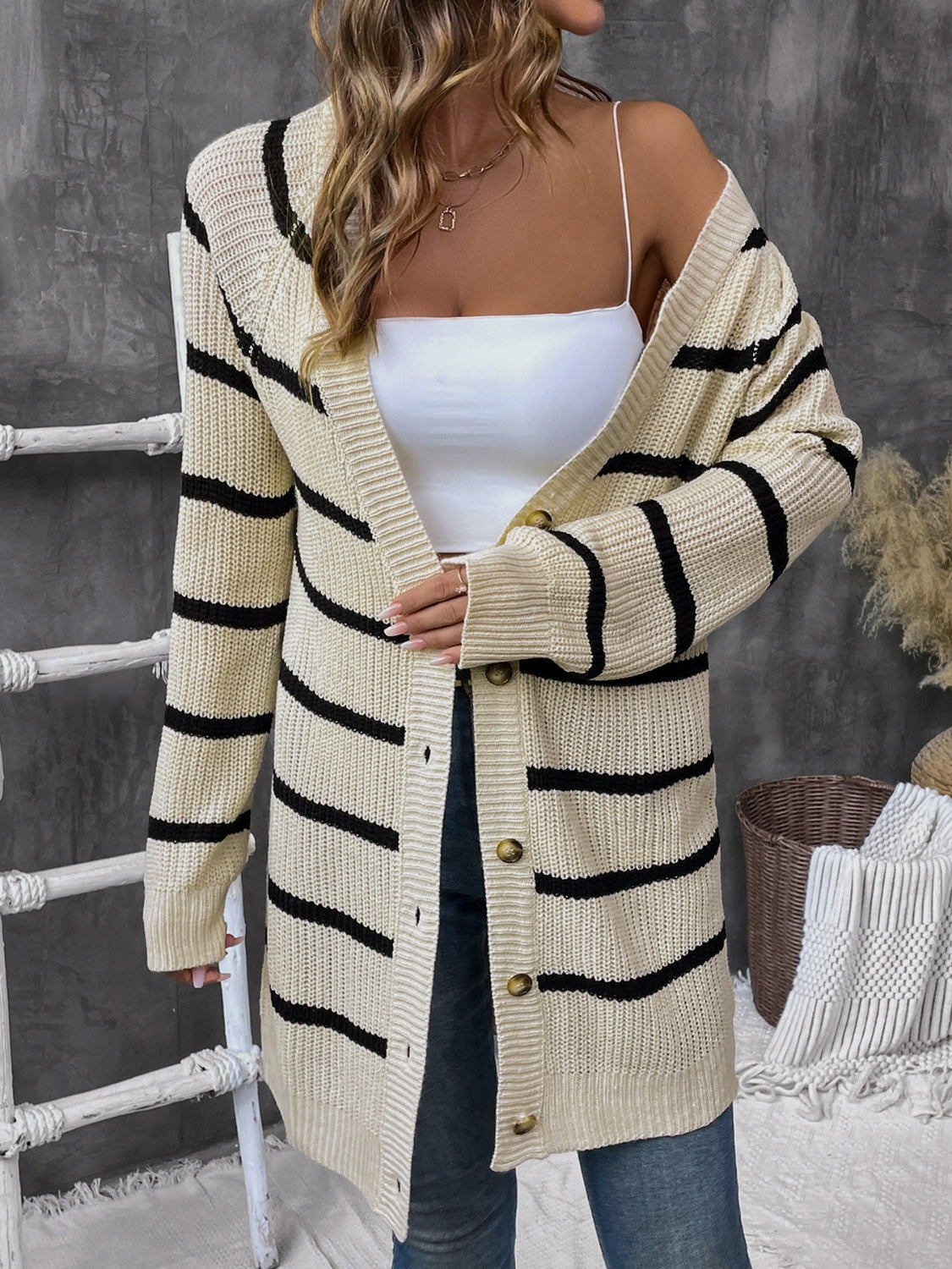 Beige acrylic knit cardigan with wide black stripes and button front.