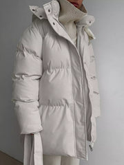 Thick puffer trench coat in ivory white with hood and belt detail.