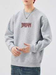 Oversized gray crew-neck sweatshirt with embroidered DREAM graphic.