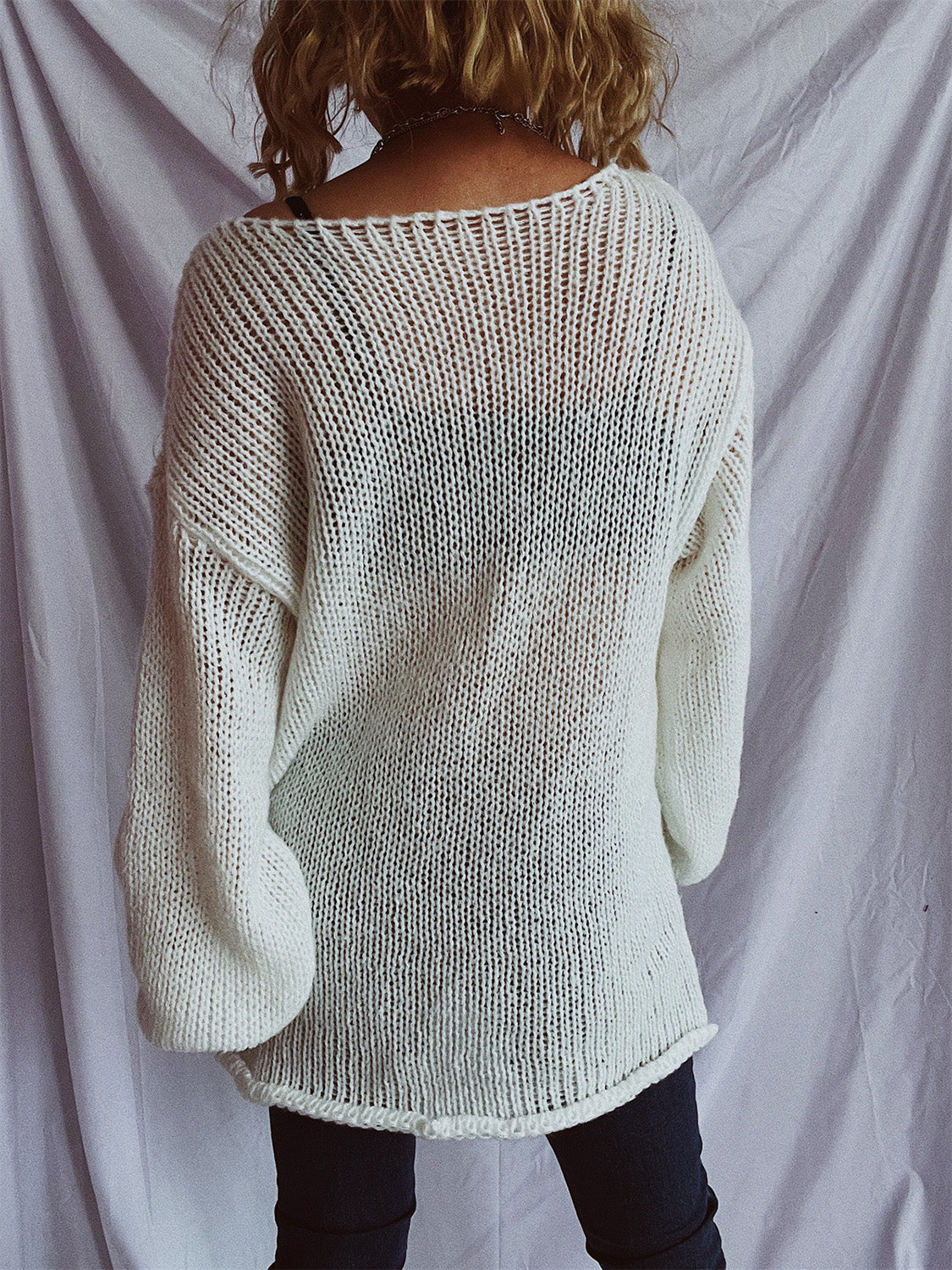 White open-knit slouchy boatneck pullover sweater with wide sleeves.