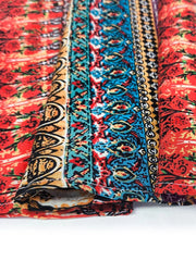 Bohemian maxi dress detail with red floral print and colorful tribal border fabric.