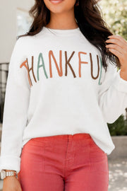 White drop shoulder sweater with "Thankful" embroidery in multi-color yarn.