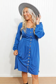 Blue button-down empire waist mini dress with long sleeves and square neckline