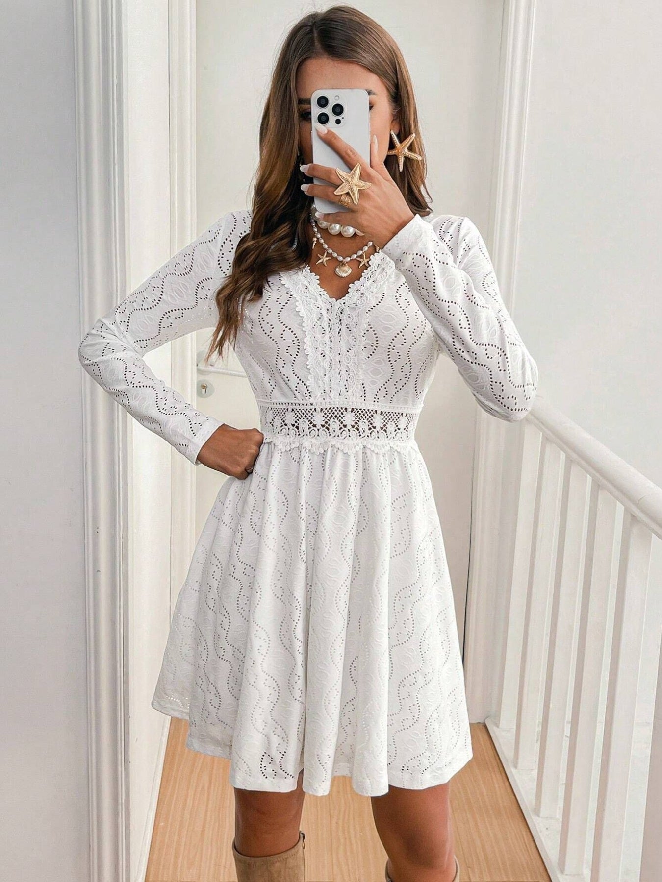 White lace openwork V-neck dress with long sleeves and an a-line skirt.